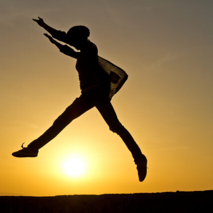 Photo of Person jumping in front of sunset
